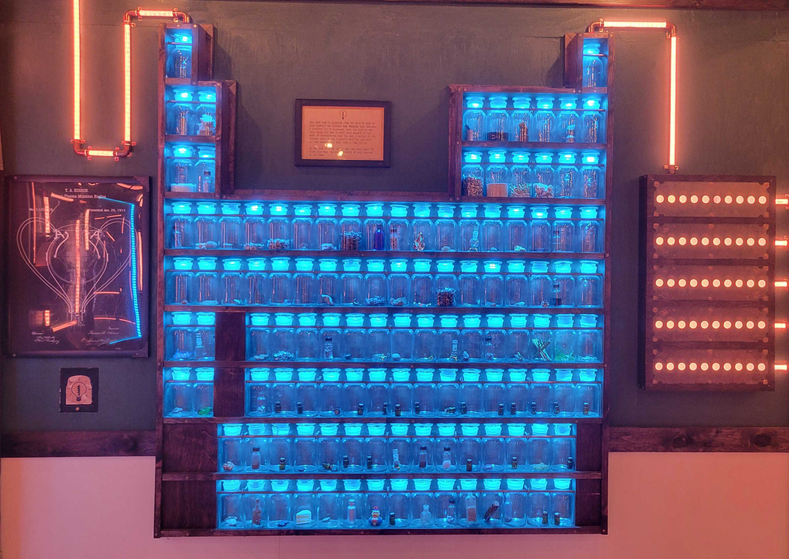 Wall of jars arranged as the periodic table, glowing blue